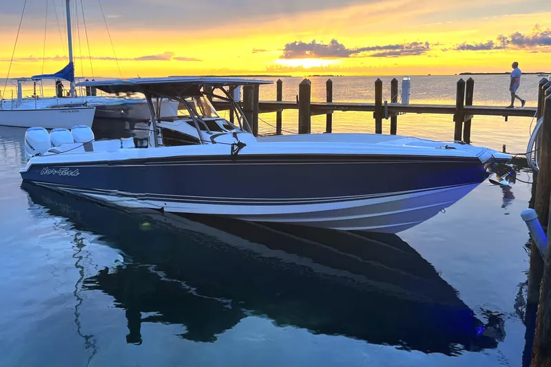 Slide: The Image of 2023 Nor-Tech 340 Sport Open Center Console boat at sunset, docked by the pier. - 7