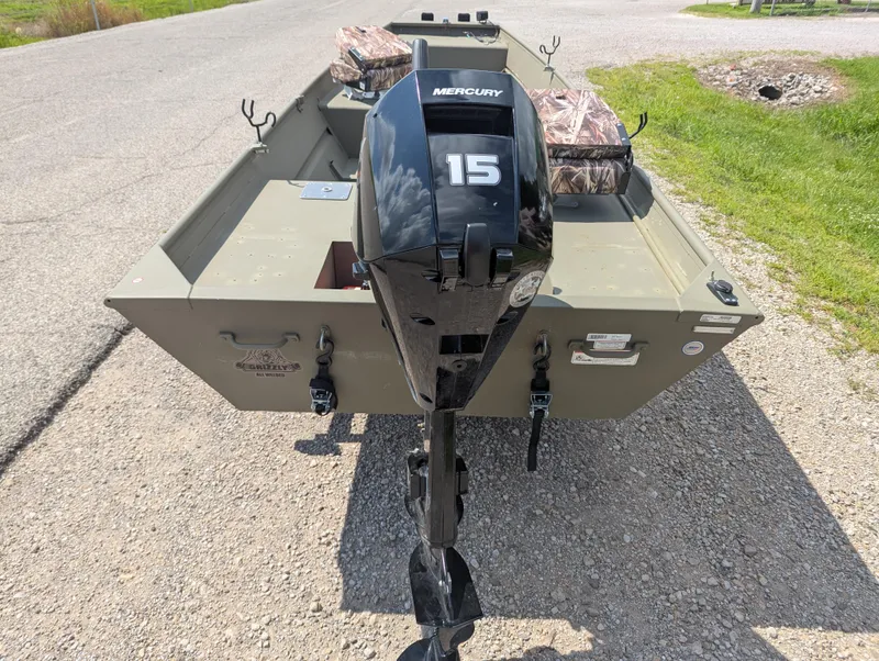 Slide: The Image of 2025 Tracker Grizzly 15 Jon boat with Mercury 15 outboard motor on gravel road. - 22