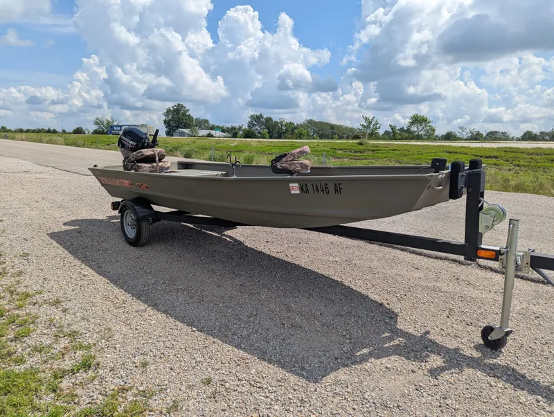 Slide: The Image of 2025 Tracker Grizzly 15 Jon boat on trailer under a cloudy sky. - 26