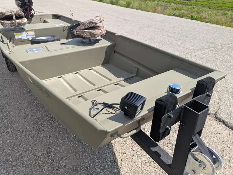 Slide: The Image of 2025 Tracker Grizzly 15 Jon boat on trailer, parked on gravel road. - 28