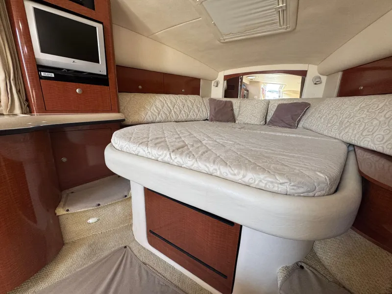 Slide: The Image of Interior cabin of 2005 Sea Ray 320 Sundancer with bed, TV, and wood accents. - 14