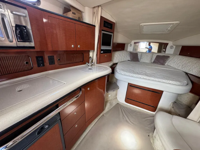 Slide: The Image of 2005 Sea Ray 320 Sundancer interior with kitchenette and cozy sleeping area. - 15