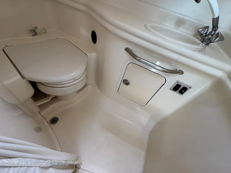 Slide: The Image of 2005 Sea Ray 320 Sundancer bathroom with toilet, sink, and storage compartment. - 18