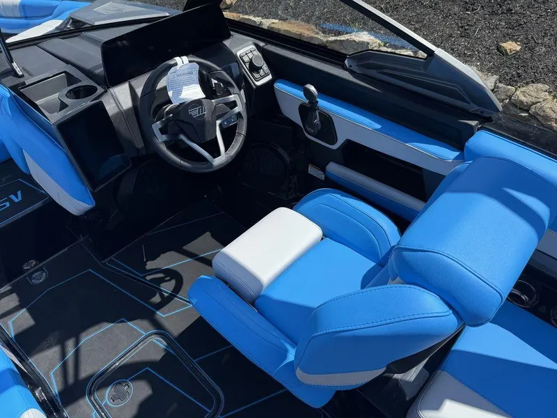 Slide: The Image of 2026 Malibu 22 LSV boat interior with blue and white seating, modern dashboard, and steering wheel. - 5