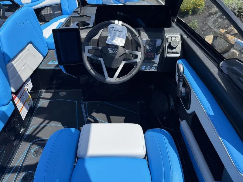 Slide: The Image of 2026 Malibu 22 LSV boat interior with blue and white seating, modern dashboard, and steering wheel. - 8