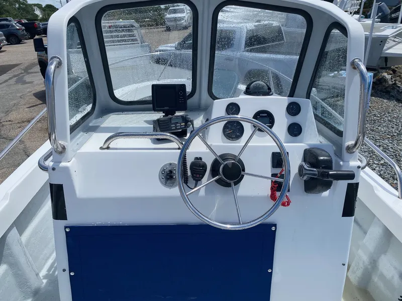 Slide: The Image of 1999 Maritime Skiff 20D boat dashboard with steering wheel and navigation instruments. - 4