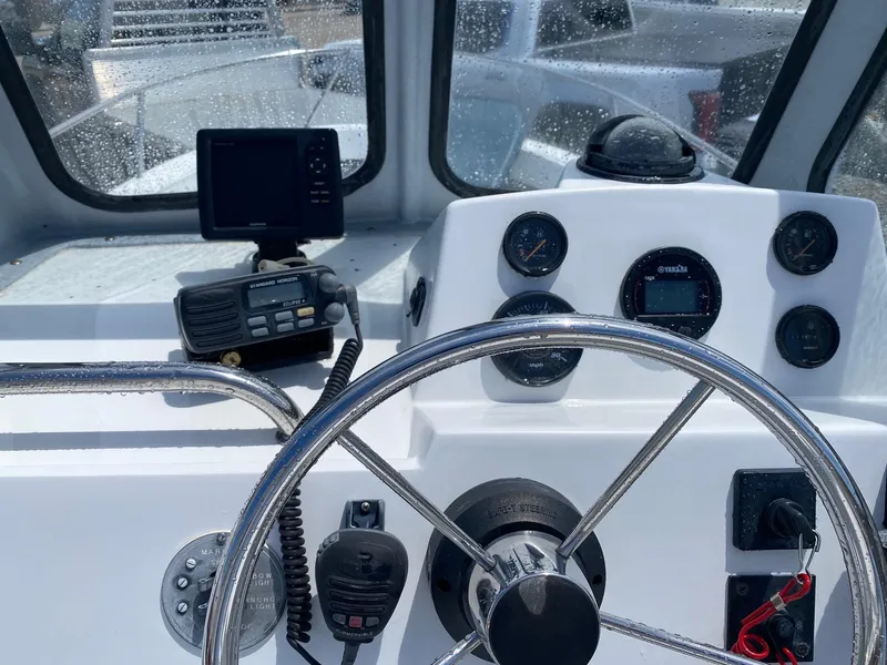 Slide: The Image of 1999 Maritime Skiff 20D boat dashboard with steering wheel and navigation instruments. - 5