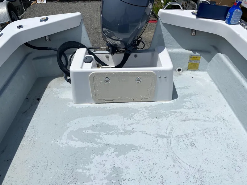 Slide: The Image of 1999 Maritime Skiff 20D boat interior with motor and storage compartment. - 9