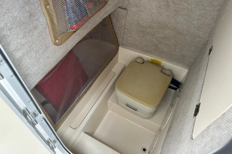 Slide: The Image of 2004 Grady-White Fisherman 222 boat interior with portable toilet and storage compartment. - 48