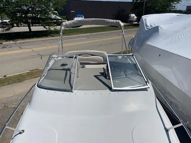 Slide: The Image of 1999 Four Winns 258 Vista boat with open windshield, parked outdoors. - 11