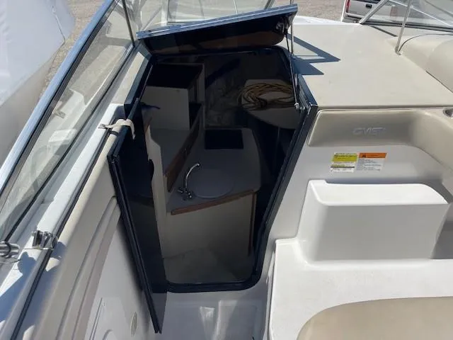 Slide: The Image of 1999 Four Winns 258 Vista boat interior with open cabin door and visible sink. - 13