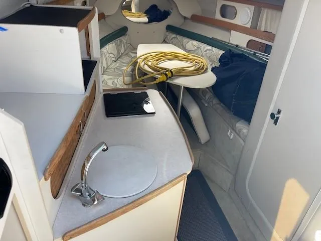 Slide: The Image of Interior of 1999 Four Winns 258 Vista boat with kitchenette and seating area. - 14