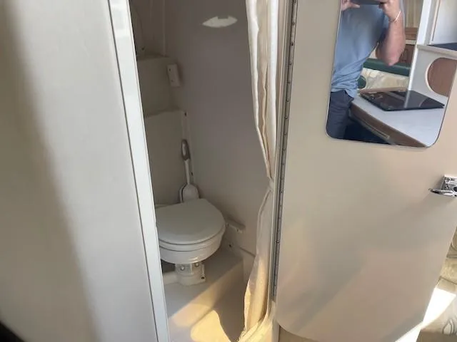 Slide: The Image of 1999 Four Winns 258 Vista boat bathroom with toilet and mirror. - 18