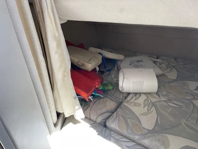 Slide: The Image of 1999 Four Winns 258 Vista cabin interior with life jackets and bedding. - 20