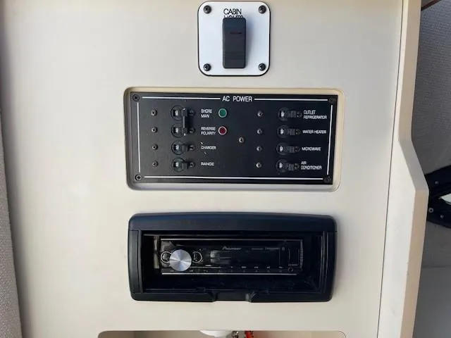 Slide: The Image of 1999 Four Winns 258 Vista control panel with AC power switches and audio system. - 21