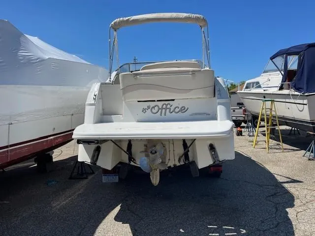 Slide: The Image of 1999 Four Winns 258 Vista boat docked, rear view, with "Office" nameplate. - 4