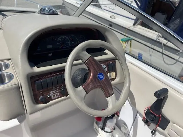 Slide: The Image of 1999 Four Winns 258 Vista boat dashboard with steering wheel and control panel. - 9