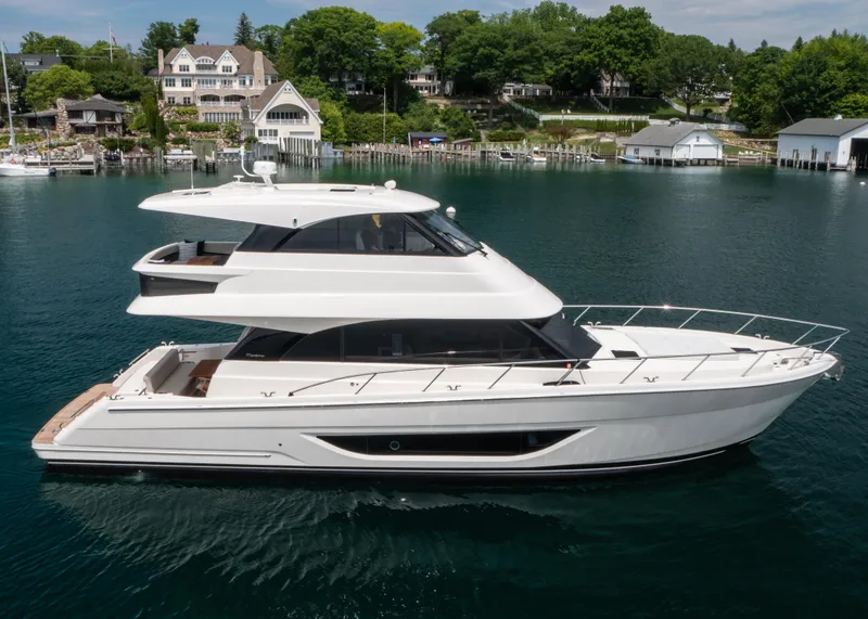 Slide: The Image of 2024 Maritimo M55 yacht on serene water, with luxurious waterfront homes in the background. - 0
