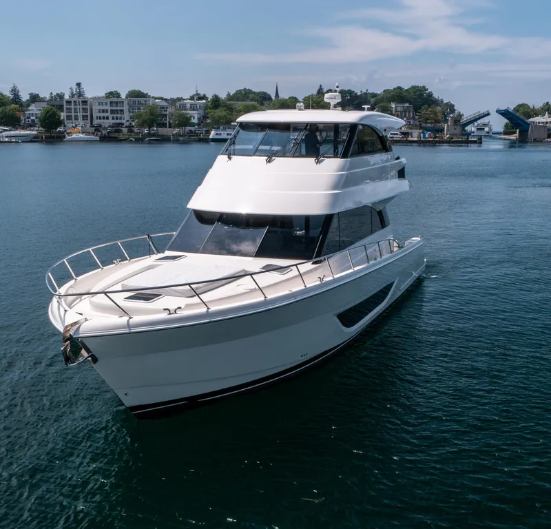 Slide: The Image of 2024 Maritimo M55 yacht cruising on a serene waterway with scenic background. - 2