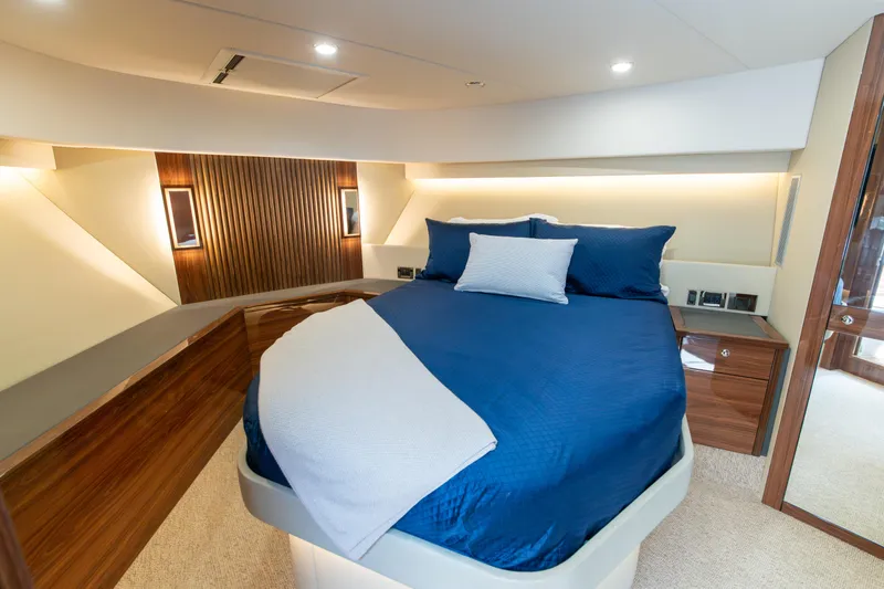 Slide: The Image of Luxurious 2024 Maritimo M55 yacht bedroom with elegant blue bedding and modern wood accents. - 59