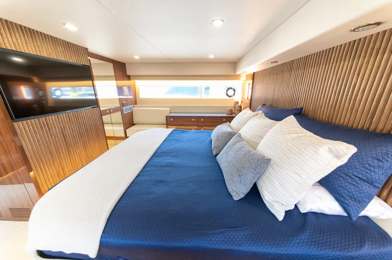 Slide: The Image of Luxurious bedroom interior of 2024 Maritimo M55 yacht with elegant wood paneling and plush bedding. - 66