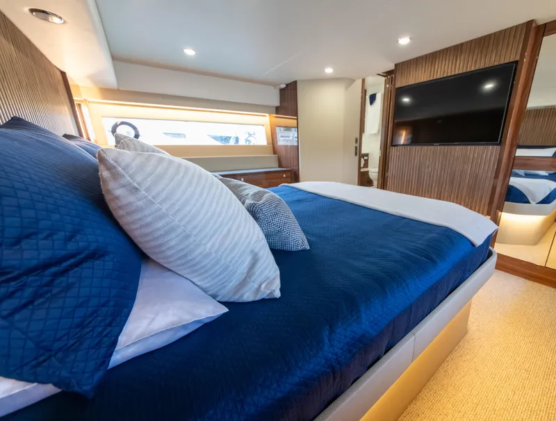 Slide: The Image of Luxurious bedroom interior of 2024 Maritimo M55 yacht with blue bedding and modern decor. - 68