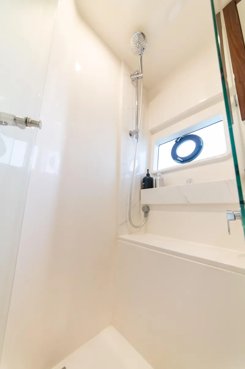 Slide: The Image of Luxurious shower area in 2024 Maritimo M55 yacht, featuring modern fixtures and a porthole window. - 74