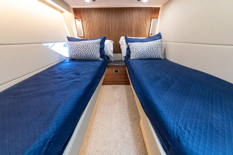 Slide: The Image of 2024 Maritimo M55 yacht cabin with twin beds, blue bedding, and modern design. - 76