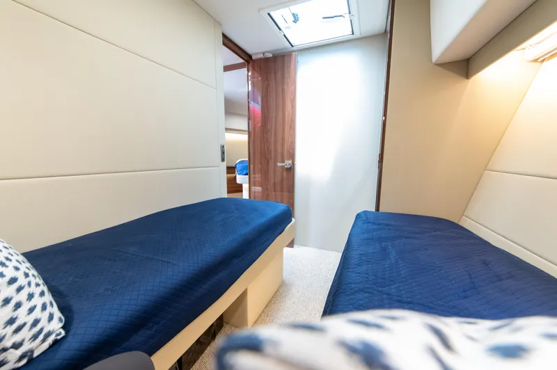 Slide: The Image of 2024 Maritimo M55 yacht cabin with twin beds and blue bedding. - 77