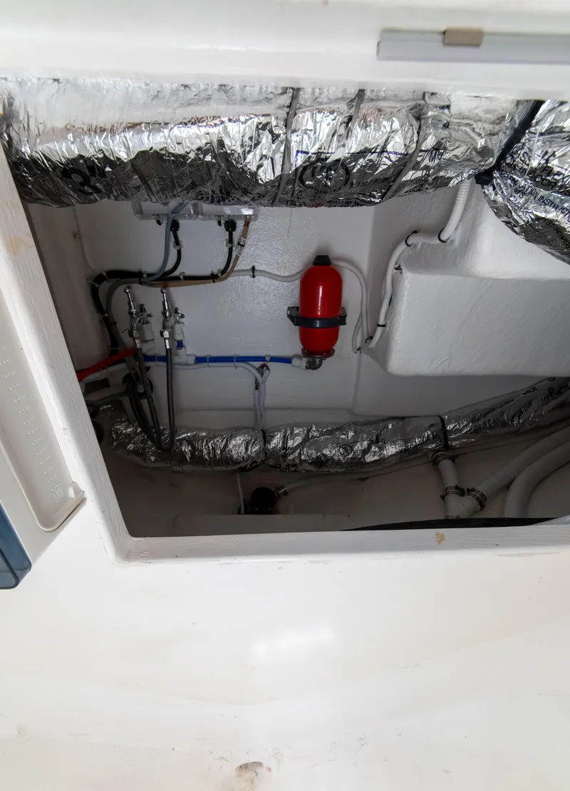 Slide: The Image of Engine compartment of 2024 Maritimo M55 yacht, showing insulated pipes and red fire extinguisher. - 83