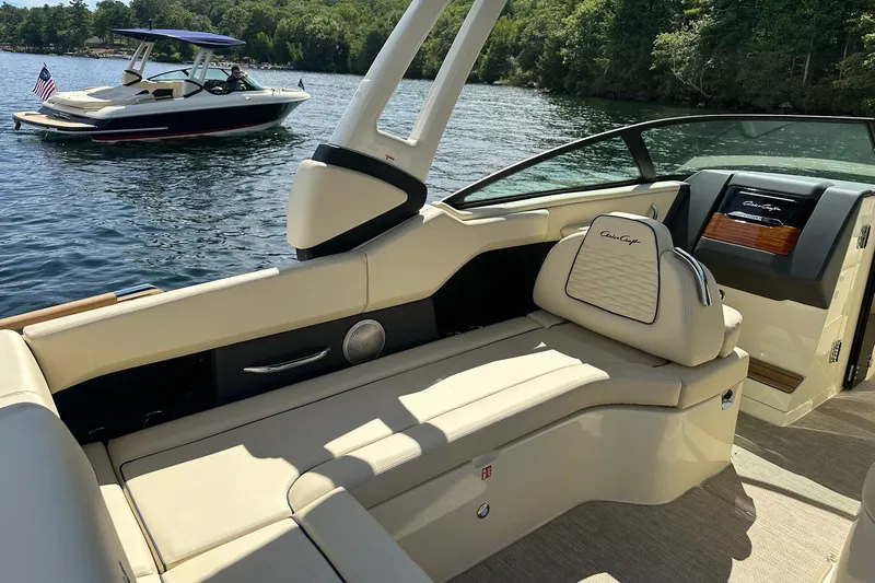 Slide: The Image of 2026 Chris-Craft Sportster 28 interior with luxurious seating on a sunny lake. - 15