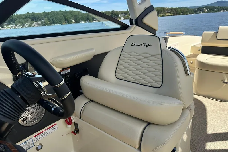 Slide: The Image of 2026 Chris-Craft Sportster 28 interior with luxurious seating and steering wheel, lake view. - 27