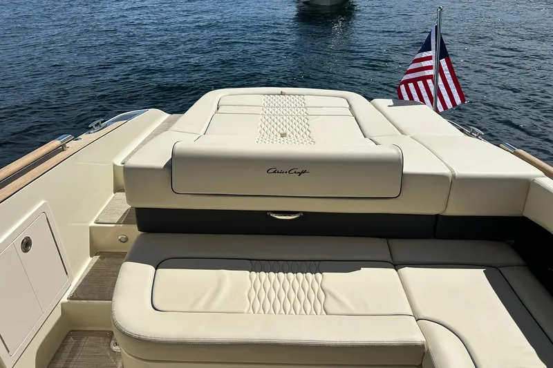 Slide: The Image of 2026 Chris-Craft Sportster 28 boat with elegant seating and American flag on water. - 32