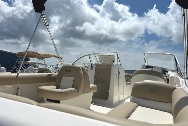 Slide: The Image of 2017 Key West 239 DFS boat interior with beige seating under a cloudy sky. - 9