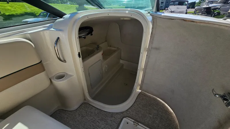 Slide: The Image of Interior cabin of 2000 Chris-Craft 262 Sport Deck boat, featuring seating and storage. - 13