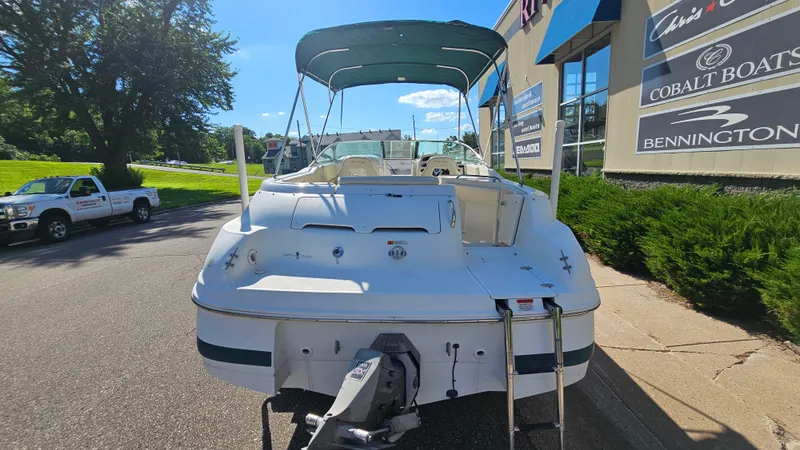 Slide: The Image of 2000 Chris-Craft 262 Sport Deck boat with canopy, parked near dealership. - 5