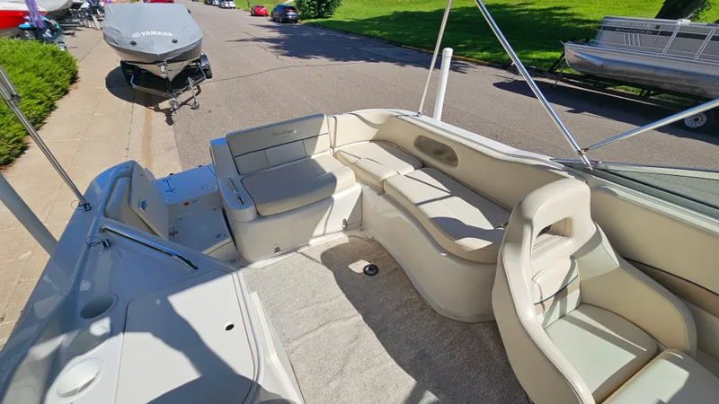 Slide: The Image of 2000 Chris-Craft 262 Sport Deck boat interior with beige seating and carpeted floor. - 7