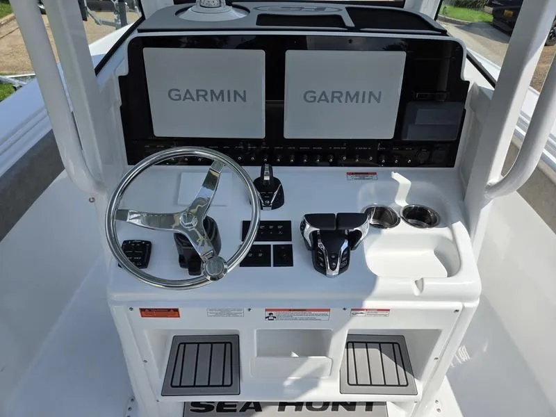 Slide: The Image of 2026 Sea Hunt Ultra 275se boat dashboard with Garmin displays and steering wheel. - 4