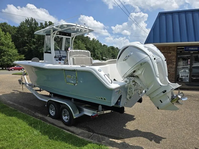 Slide: The Image of 2026 Sea Hunt Ultra 275se boat on trailer, parked outdoors near a Yamaha store. - 5