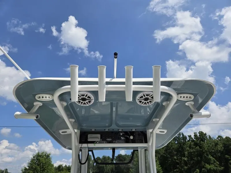 Slide: The Image of 2026 Sea Hunt Ultra 275se boat top with rod holders and speakers against blue sky. - 8