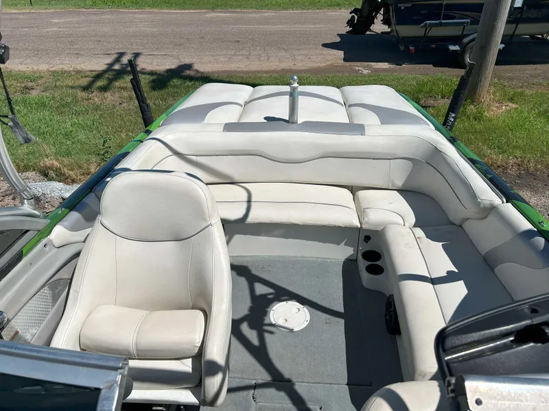 Slide: The Image of 2002 MasterCraft XStar boat interior with white seating and green accents, parked on grass. - 5