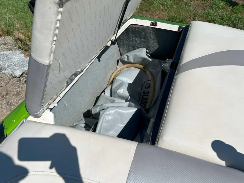 Slide: The Image of Open storage compartment in a 2002 MasterCraft XStar boat with interior items visible. - 7