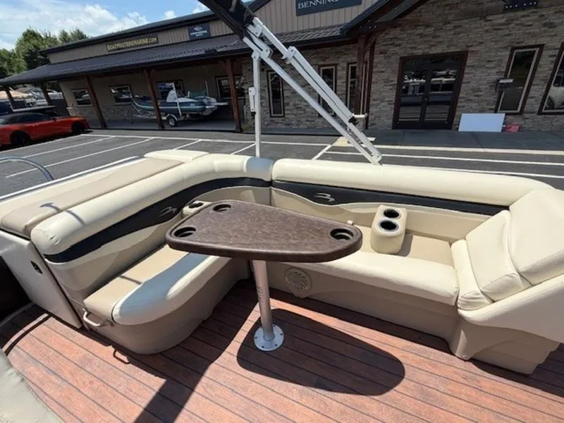 Slide: The Image of 2014 Bennington 22 SLX boat interior with beige seating and wooden table. - 17