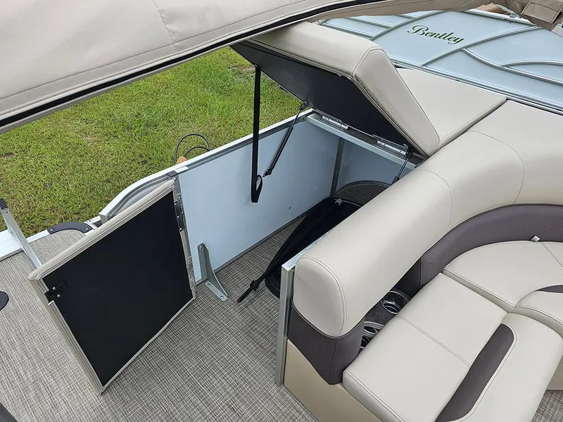 Slide: The Image of 2026 Bentley Pontoons Legacy 243 Cruise interior with beige seating and storage compartment. - 12