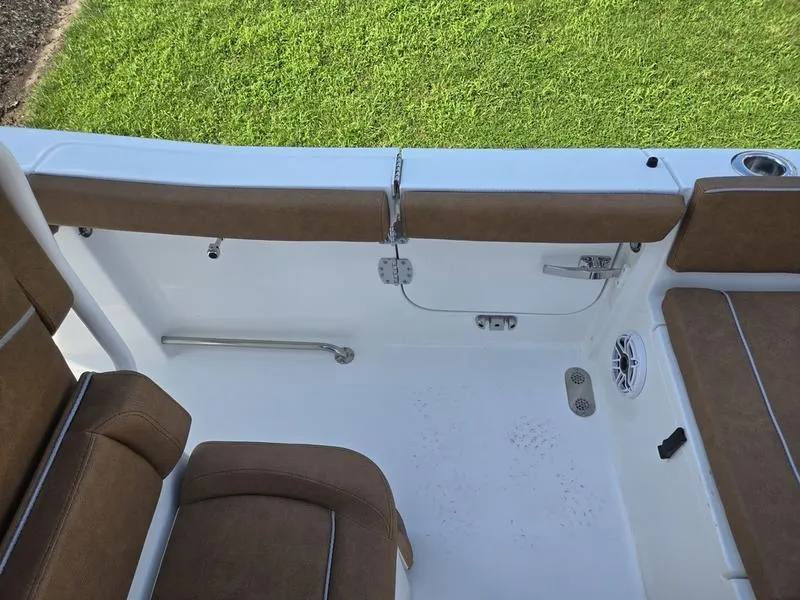 Slide: The Image of 2026 Sea Hunt Ultra 255se boat interior with brown seating and white deck. - 15