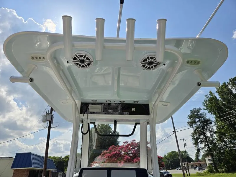 Slide: The Image of 2026 Sea Hunt Ultra 255se boat with rod holders and speakers under a clear sky. - 16