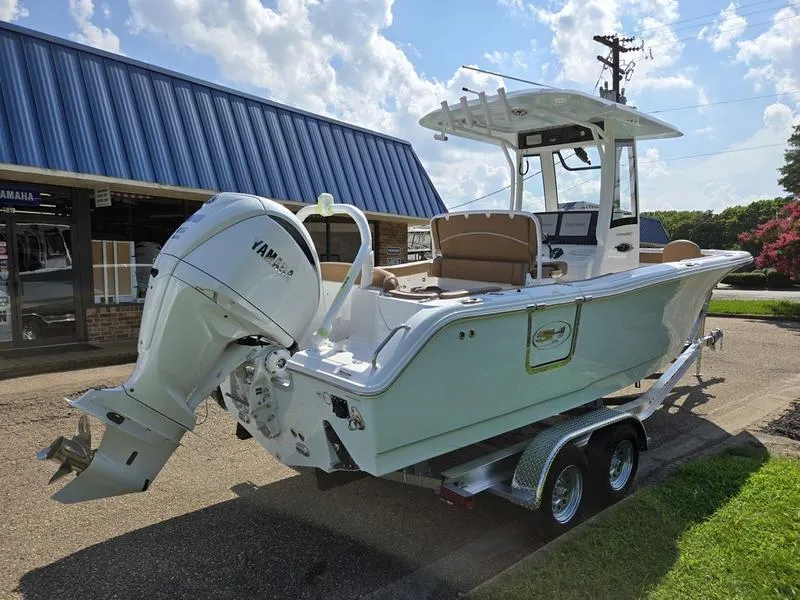 Slide: The Image of 2026 Sea Hunt Ultra 255se boat on trailer, parked outdoors under blue sky. - 4