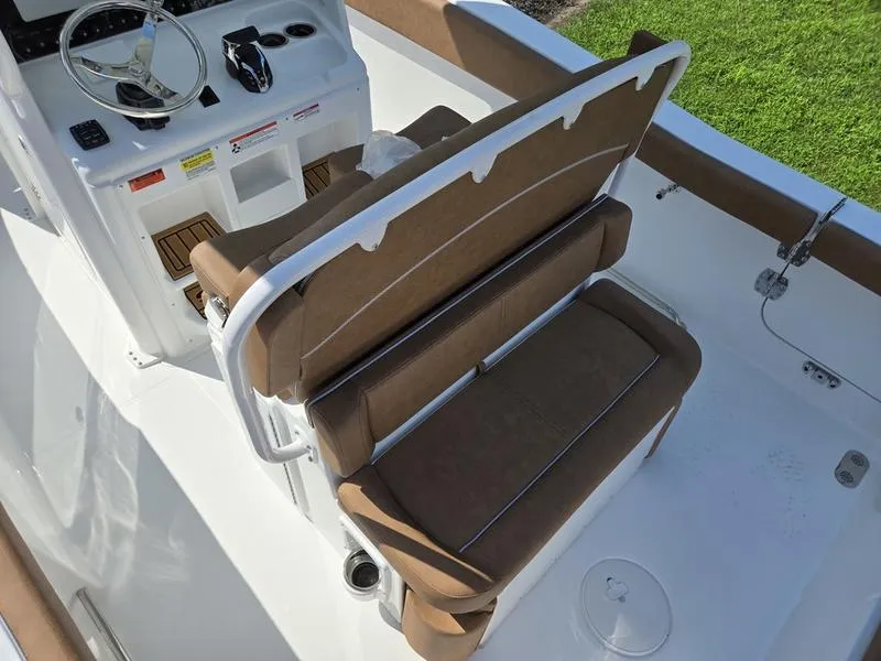 Slide: The Image of 2026 Sea Hunt Ultra 255se boat interior with brown seating and steering console. - 9