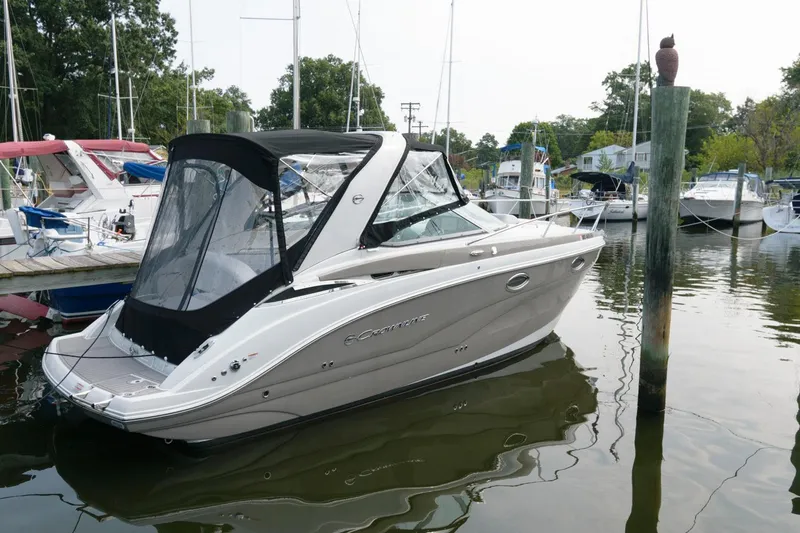 The Image of 2021 Crownline 264 CR boat docked in a marina, featuring sleek design and canopy. - 0