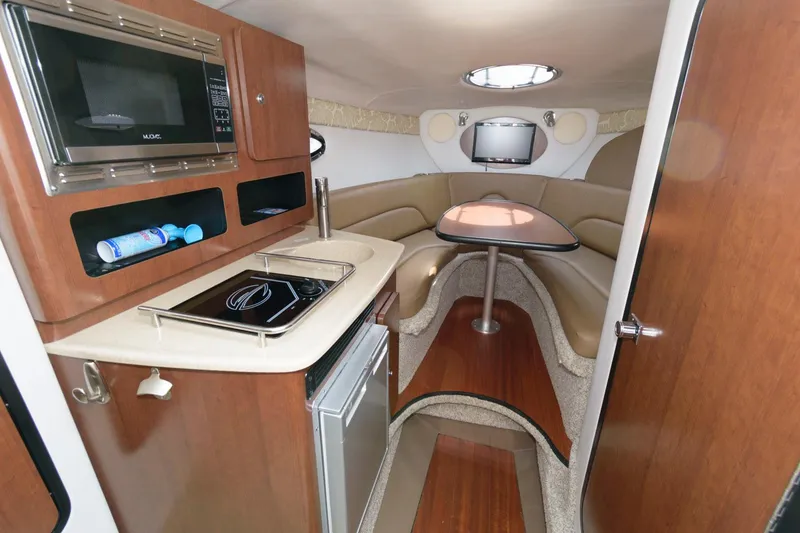 Slide: The Image of 2021 Crownline 264 CR cabin interior with kitchenette and seating area. - 12